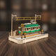 Puzzle 3D de tramway vert avec détails blancs et jaunes sur base bois.