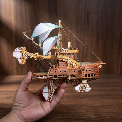 Puzzle 3D en bois d'un vaisseau spatial steampunk avec voiles et engrenages sur un socle. -vue 3